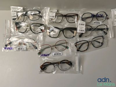 many pairs of eyeglasses in bags on the table