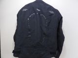 the back of a black jacket hanging on a white wall