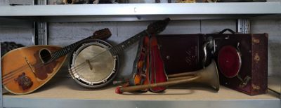 de nombreux instruments de musique posés sur une étagère dans une pièce