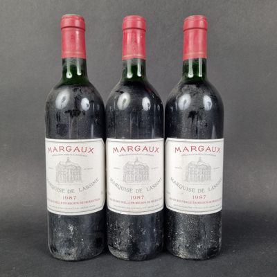 three bottles of red wine sitting on top of a table