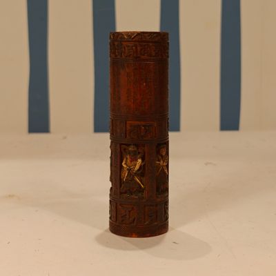 an old wooden cylinder with carvings on it sitting on a table