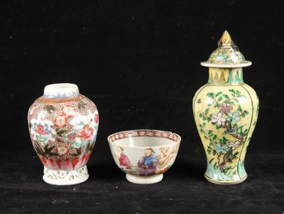 three vases and a bowl are sitting on a black surface