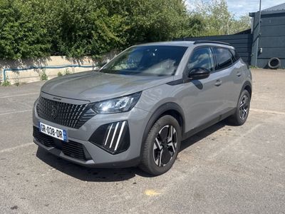 un SUV gris garé sur un parking, avec des arbres en arrière-plan