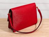 a red purse sitting on top of a wooden table