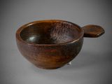 wooden bowl with a spoon on a stand on a gray surface