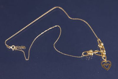 un gros plan sur un collier en or orné d'un cœur