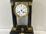 a black and gold clock with roman numerals on it