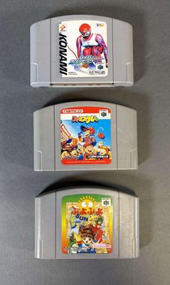 trois cartouches de jeux nintendo posées sur une table