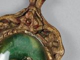 a gold and green clock with a picture of a woman on it