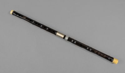 a close up of a flute with a wooden handle on a gray surface