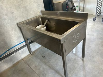 a stainless steel sink in the middle of a room