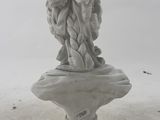 statue of a woman holding a basket of flowers on top of a white pedestal