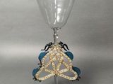 a wine glass with a gold and blue decoration on it