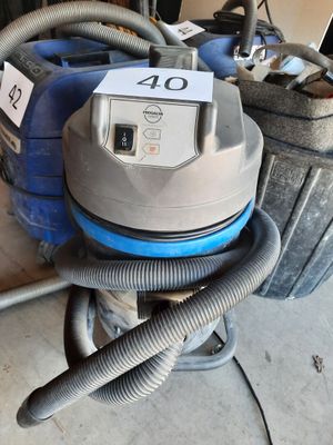 a vacuum that is sitting on the floor next to a bag