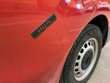 a close up of a red car with a sticker on it