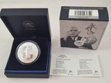 une pièce d'argent représentant un homme en costume-cravate, dans un coffret