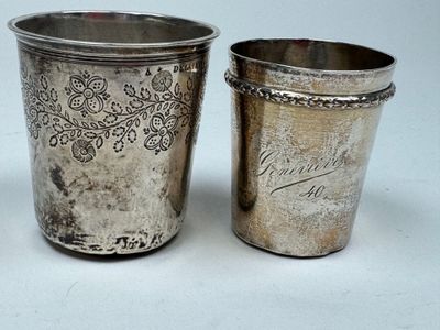 two silver cups sitting next to each other on a table