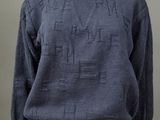 un mannequin portant un pull bleu avec des lettres dessus