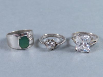 trois bagues ornées d'émeraudes et de diamants sur un fond blanc