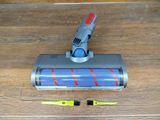 a vacuum that is sitting on the floor next to a brush
