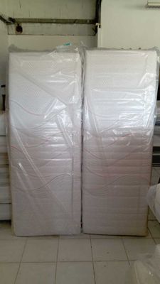 a large stack of white mattresses in a room