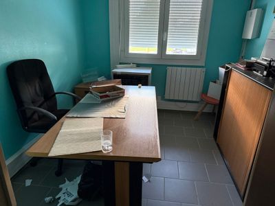 un bureau avec une chaise et une fenêtre dans la pièce