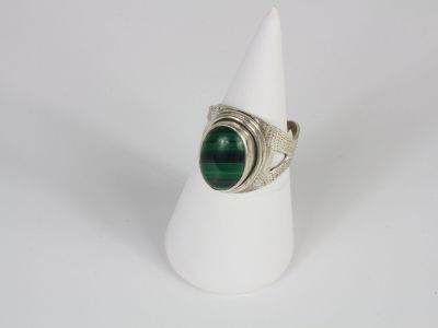 a close up of a ring with a green stone on it