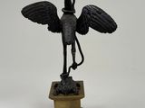 bronze statue of a bird on a pedestal on a white background