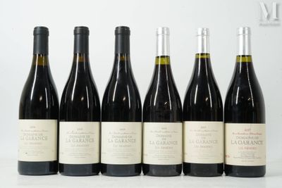six bouteilles de vin sont alignées sur une table