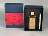 une photo d'un flacon de parfum posé dans une boîte