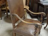 a brown leather chair sitting in a room next to a table
