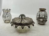 trois vases en verre posés sur une table l'un à côté de l'autre