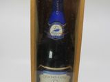 une bouteille de vin bleu dans un coffret en bois