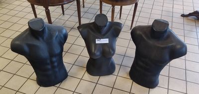 trois mannequins assis par terre dans une pièce
