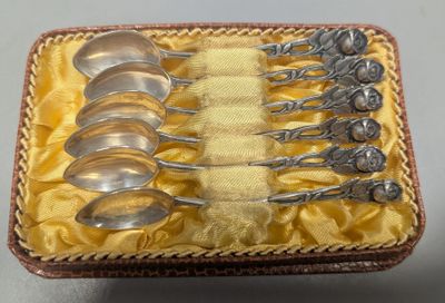 six cuillères dans une boîte posée sur une table