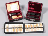 two open cases of makeup and eyeliners sitting on a table