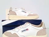 the white and beige sneakers are sitting on a blue box