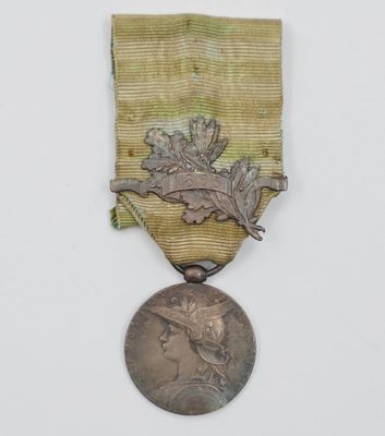 une vieille médaille ornée d'un ruban doré sur fond blanc
