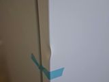 a white refrigerator with blue tape on the side of it