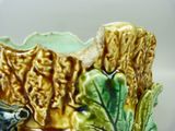 a close up of a ceramic planter with a bird on it