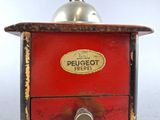 a red and black coffee grinder on a white surface