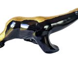 black and gold badger figurine on a white background