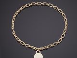 un bracelet en chaîne d'or orné d'une breloque en forme de pièce de monnaie