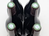several bottles of wine are lined up in a row on a white surface