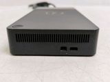 the back of a small black device sitting on a white surface