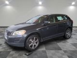 un SUV Volvo gris garé dans un garage au sol carrelé