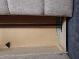 a cat that is sitting on the floor under a bed
