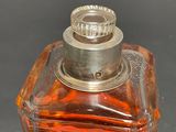 a small glass bottle with a silver lid on a table