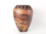 a vase with a painting on it sitting on a table