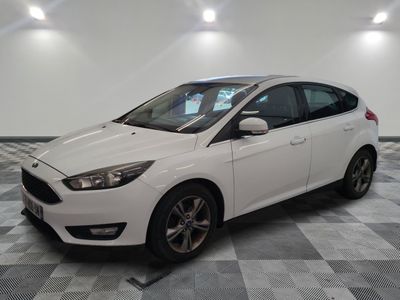 the white ford focus is parked in a room with a checkered floor